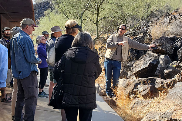 A group watches as a man points out rocks at the preserve