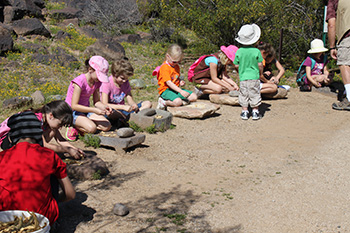 A group of children sitting outside doing an activity