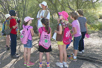 A group of children in a semicircle around an adult volunteer